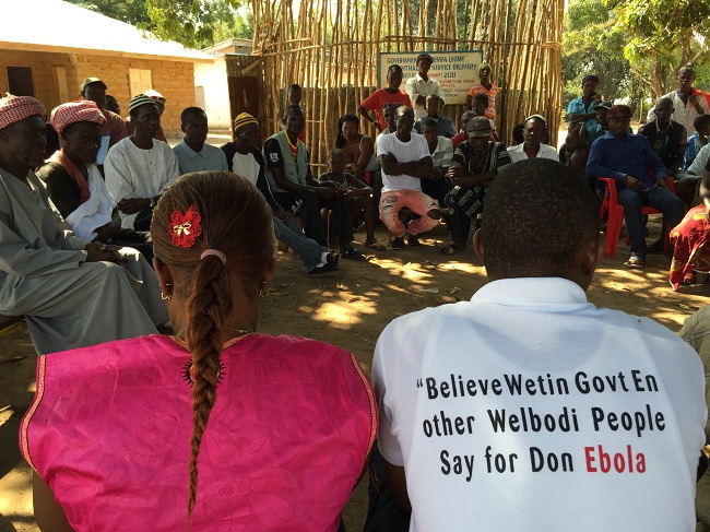 Health education meeting in Sierra Leone run by CARE International. The t-shirt says: "Believe what the government and health authorities tell you about how to stop Ebola".