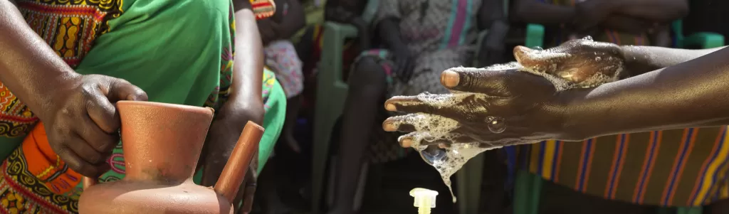 An aid worker demonstrates handwashing