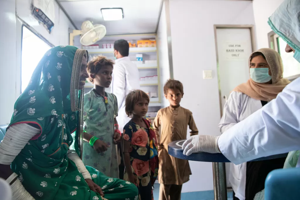 Dr. Anila, writes a prescription for a patient inside a mobile health unit 
