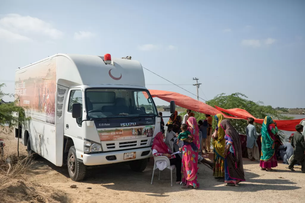 Women and children queue outside of a Mobile Health Clinic funded by DEC charity CAFOD in Sindh, Pakistan on 20th September 2022.