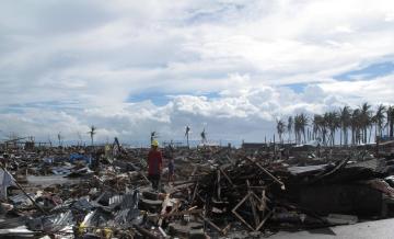 A man stands amid flattened houses in Tacloban