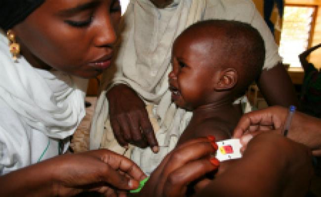 Child eats a nutrition substance called Plumpy Nut ® at a Merlin outreach clinic