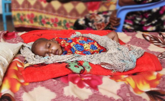 Three month old Mohammad Amin lies in the therapeutic feeding unit