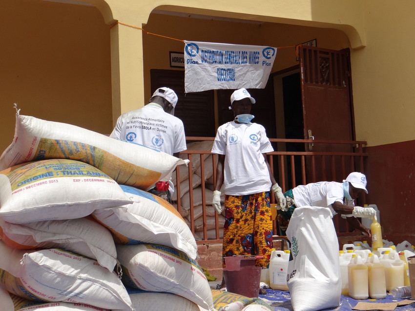 Plan staff prepare food packages at a distribution centre in Guinea