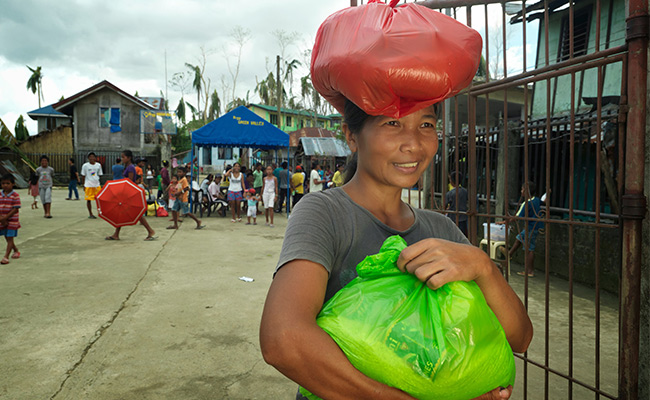 A lady leaves a CARE food distribution in southern Leyte, Philippines