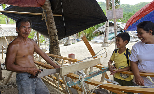 Droscoro Cayme uses the tools provided by Concern to build his boat.