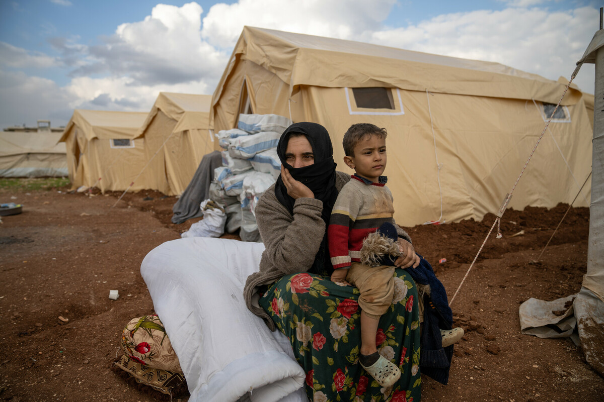 Amal * sits with her son in front of a tent in Jenderes, Syria on the 10th of February 2023
