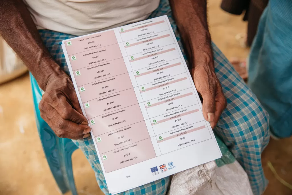 A man holds food vouchers in the Rohingya refugee camps