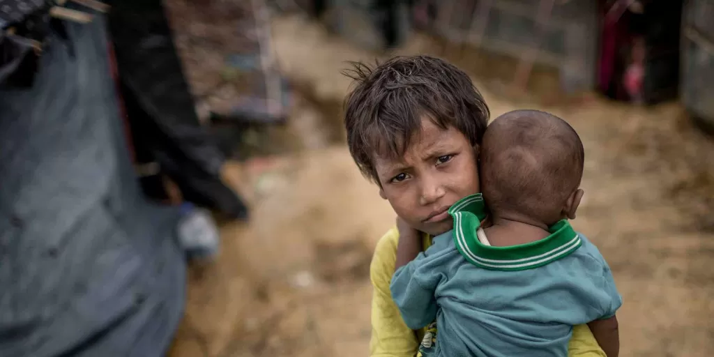 A girl carries her baby brother in the Rohingya refugee camps