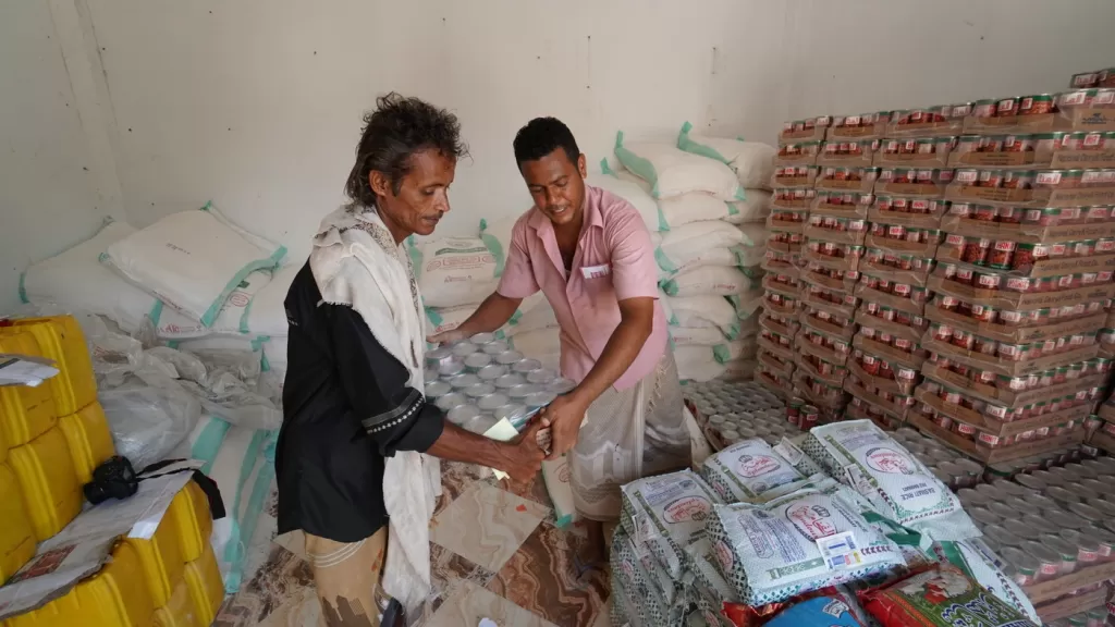 Salem, 47, collects a food parcel from a DEC-funded distribution point in Lahj, Yemen.