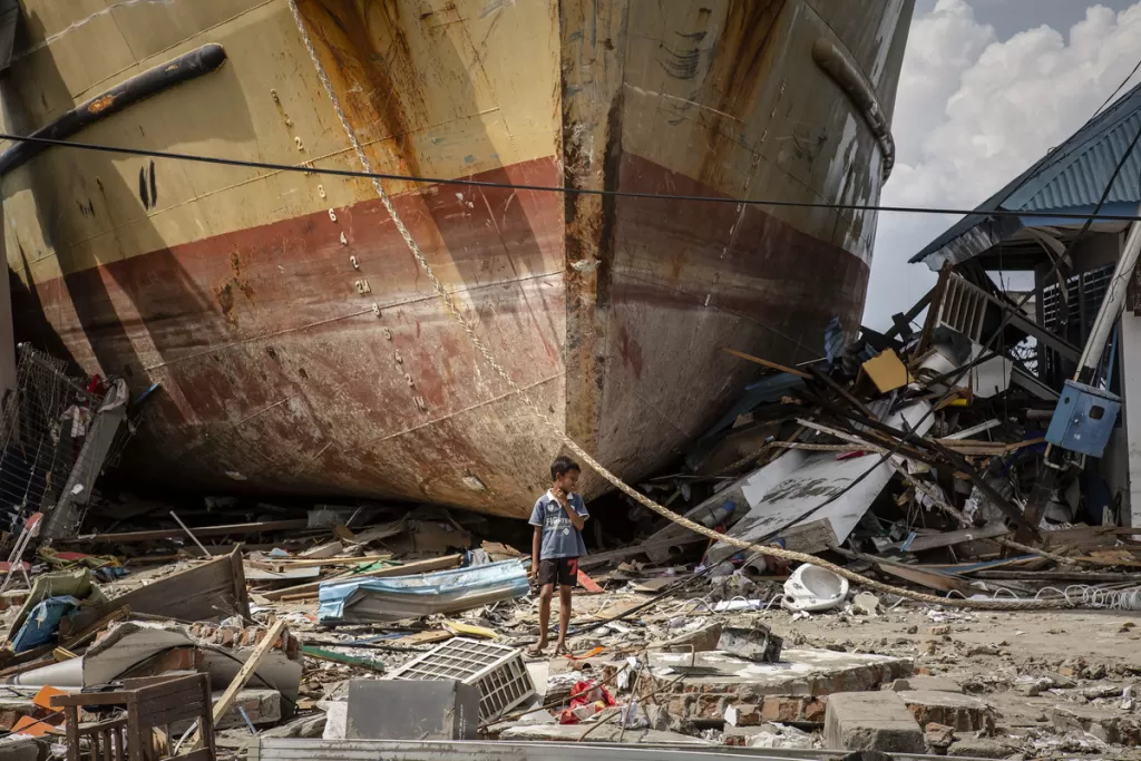 A boy stands infornt a stranded ship after hit by the tsunami on October 2, 2018 in Donggala, Central Sulawesi, Indonesia.