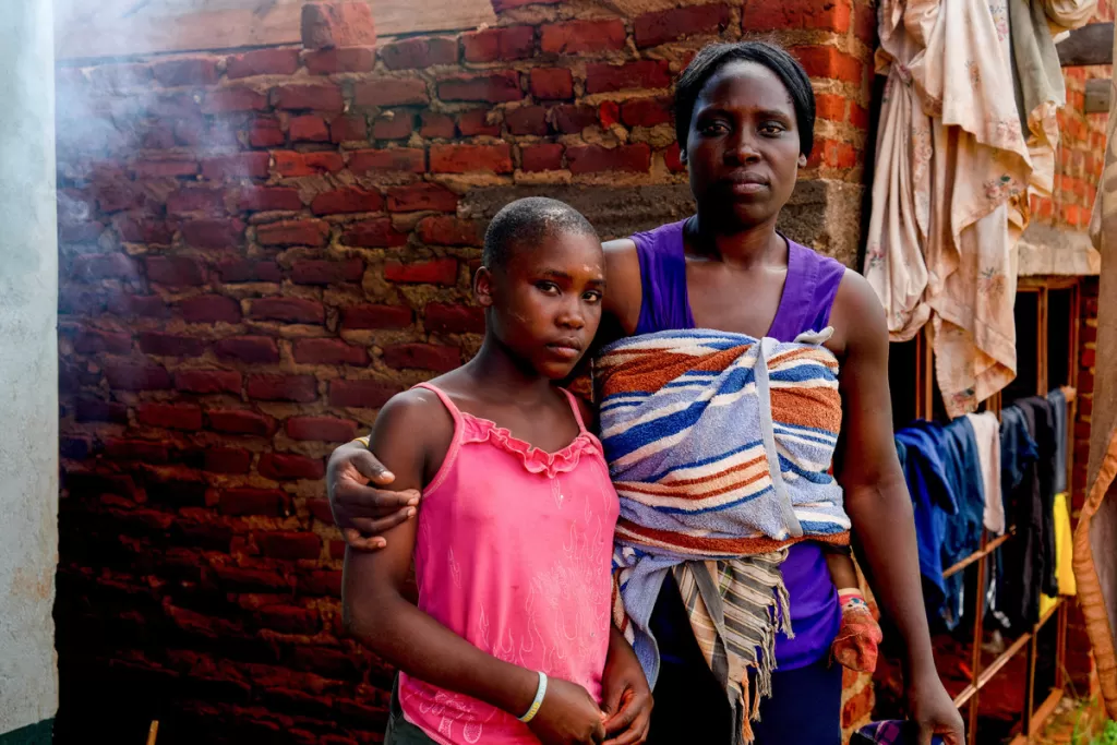 Lisper stands with her daughter Levette, who was rescued from a tree after being swept away by flood waters.