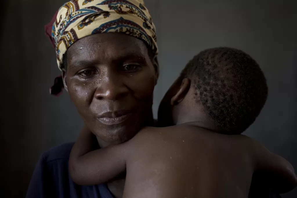 Rosa holds her son, John, who has a high fever as he is screened for malaria in Dondo, Mozambique.