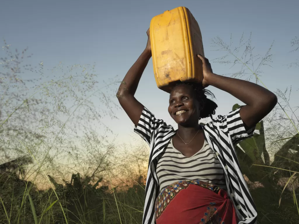 Tamara carries water from a waterpoint installed by World Vision near her house in Buzi, Mozambique which was completely flooded after the cyclone.
