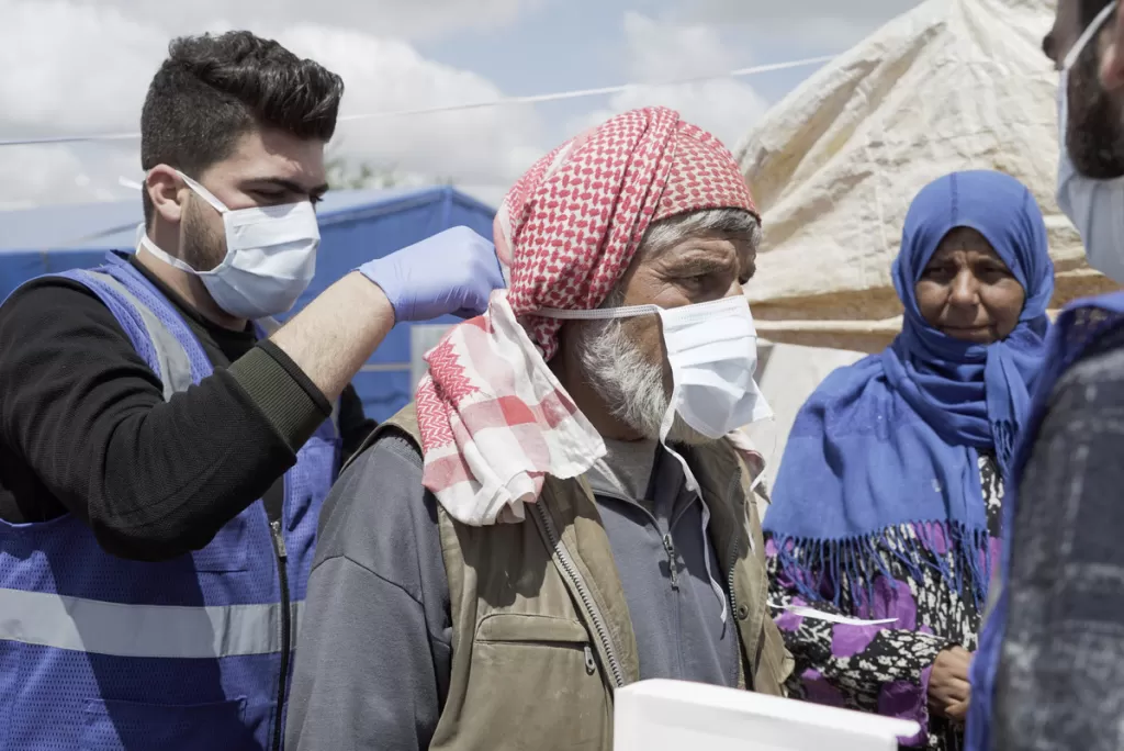 Islamic Relief provide masks to residents of a camp for people displaced by the war in Idlib province, Syria.