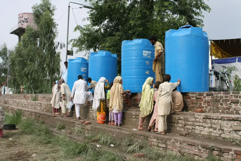People get clean water from large blue water tanks