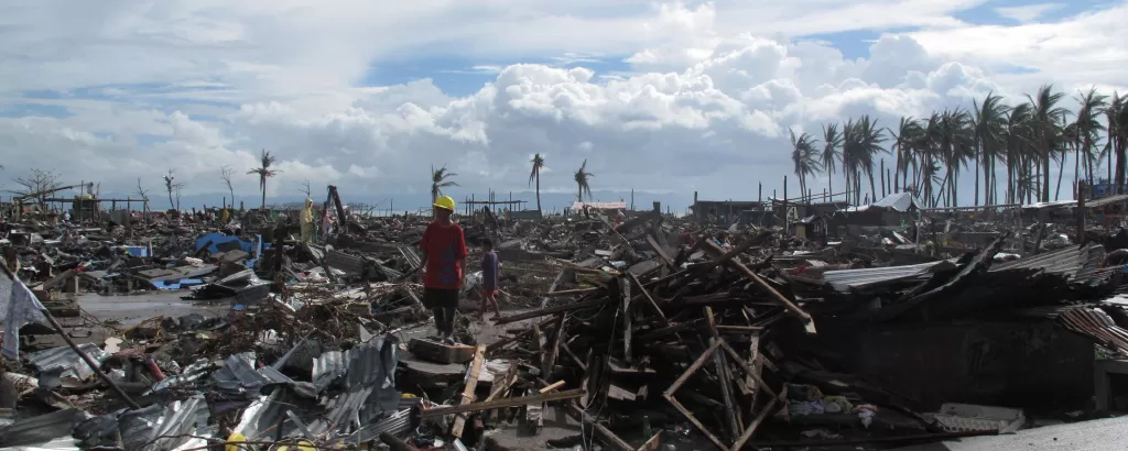 A man stands amid flattened houses in Tacloban