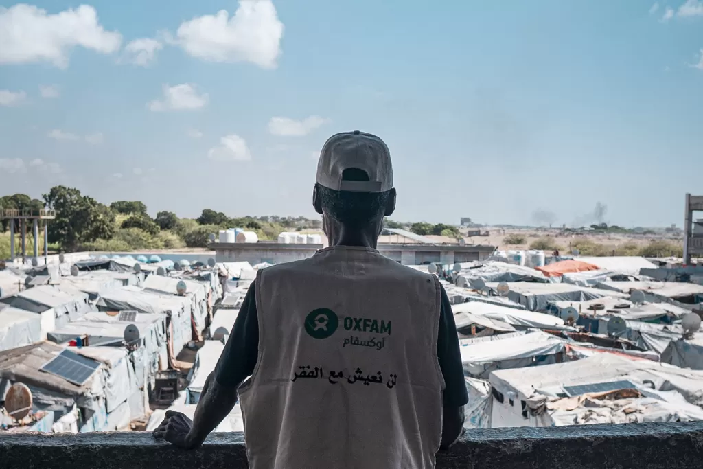 An Oxfam volunteer looks over a displacement camp