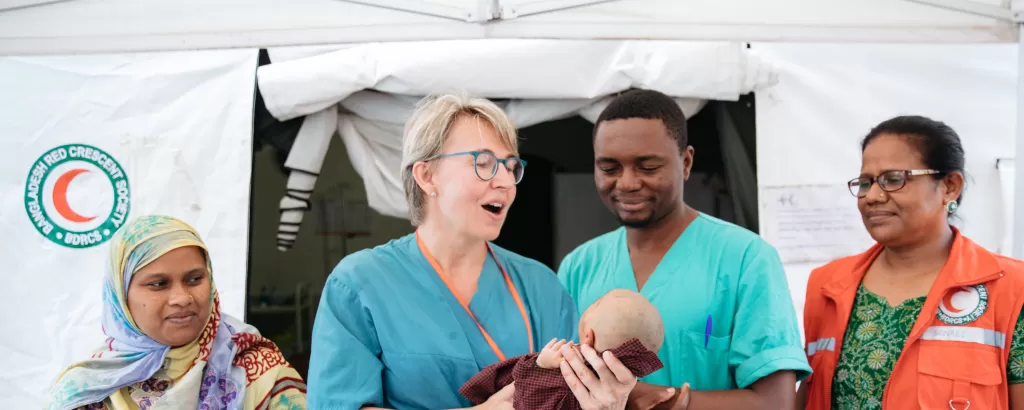 Field hospital staff hold a baby