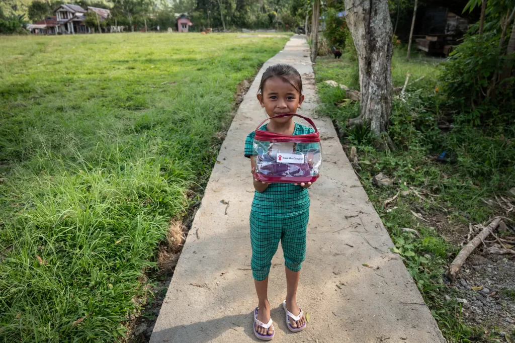 A girl holds a hygiene kit