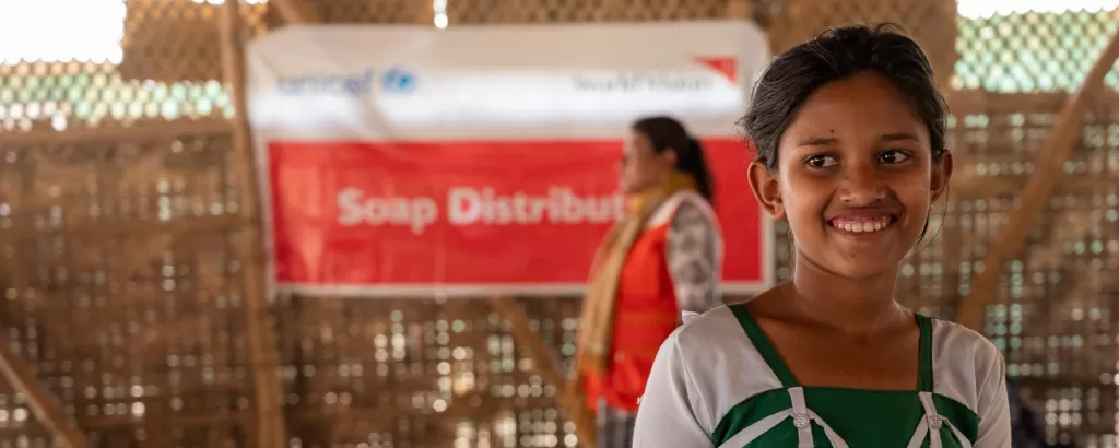 A girl carries soap from a distribution