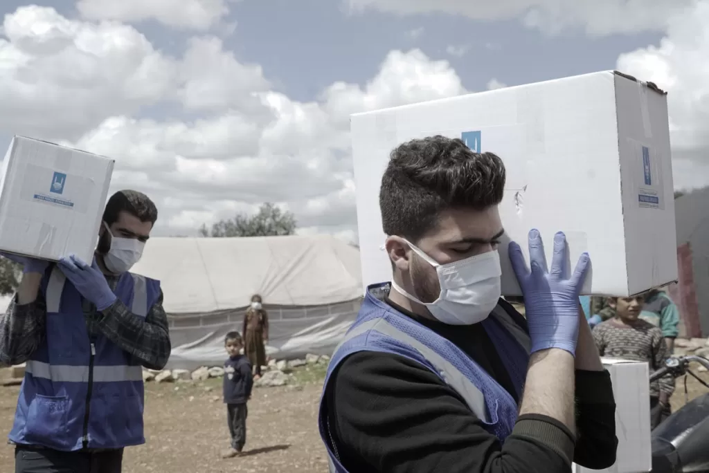 Islamic Relief aid workers carry boxes