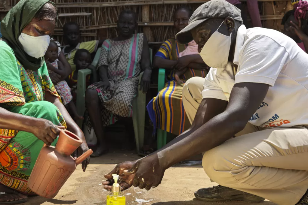 An aid worker demonstrates handwashing