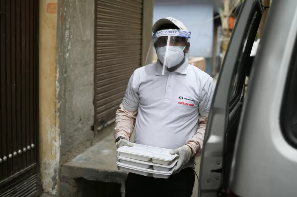 An aid worker carries food parcels