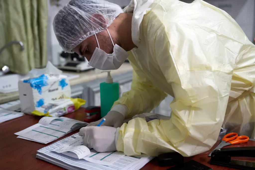 Healthcare worker Ayham Al-Sabaa analyses a patient's blood sample in the health isolation centre near Idlib in Syria