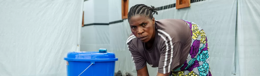 A camp resident in DR Congo washes her hands with support from a Tearfund project