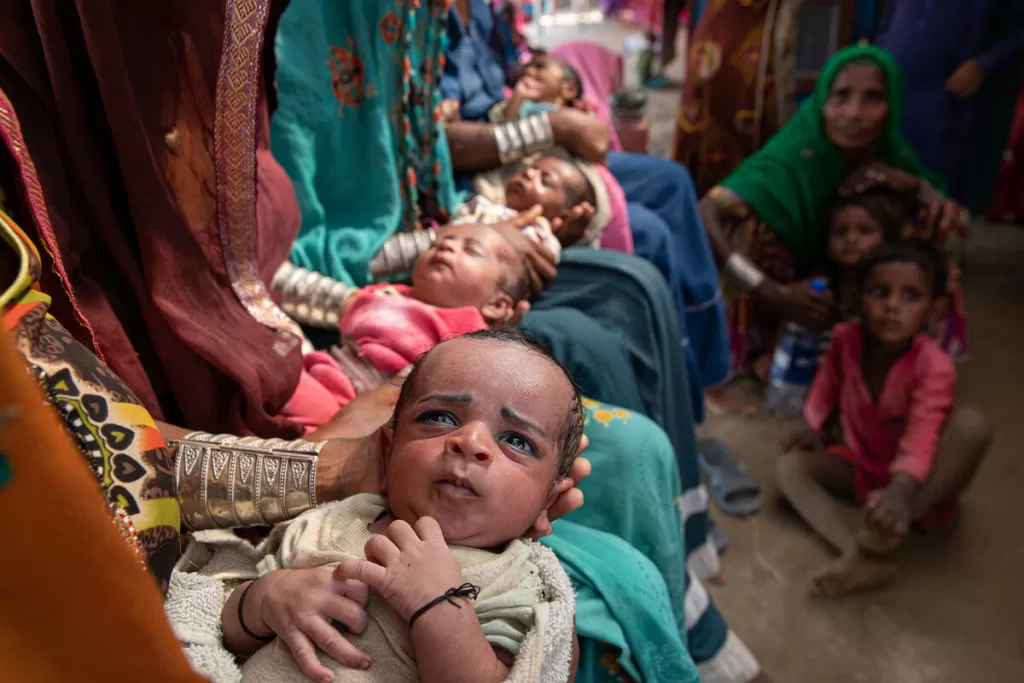 Salma * and Pani * wait with other mothers and their children for treatment in Pakistan