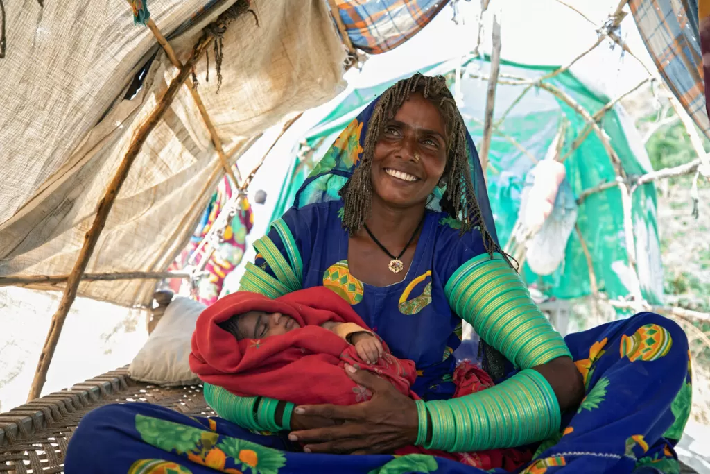 Jhaini sits with her new born baby under a temporary shelter, Pakistan
