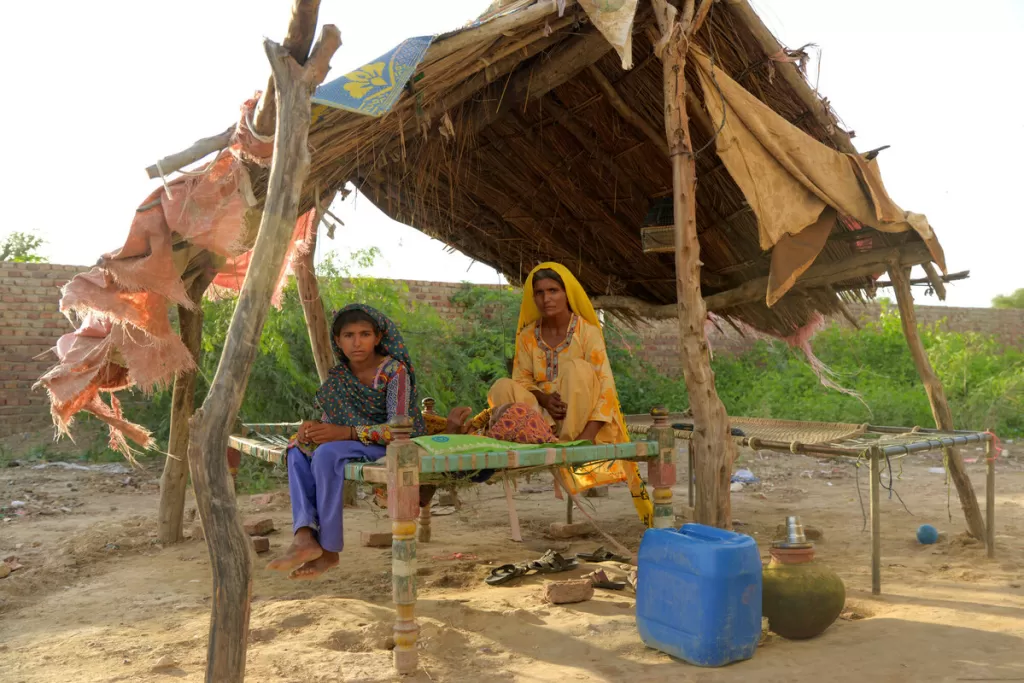 Nasra and her daughter sit in their temporary shelter in Sindh, having lost their home in the floods.