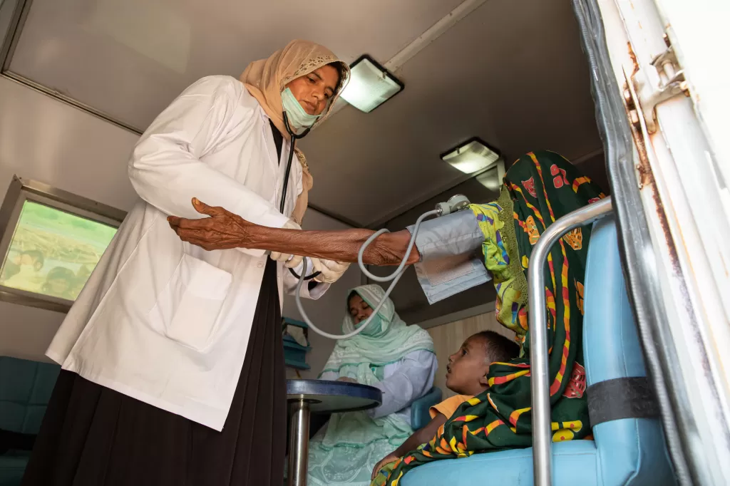 Nurse Noor checks blood pressure of a patient in the mobile health unit