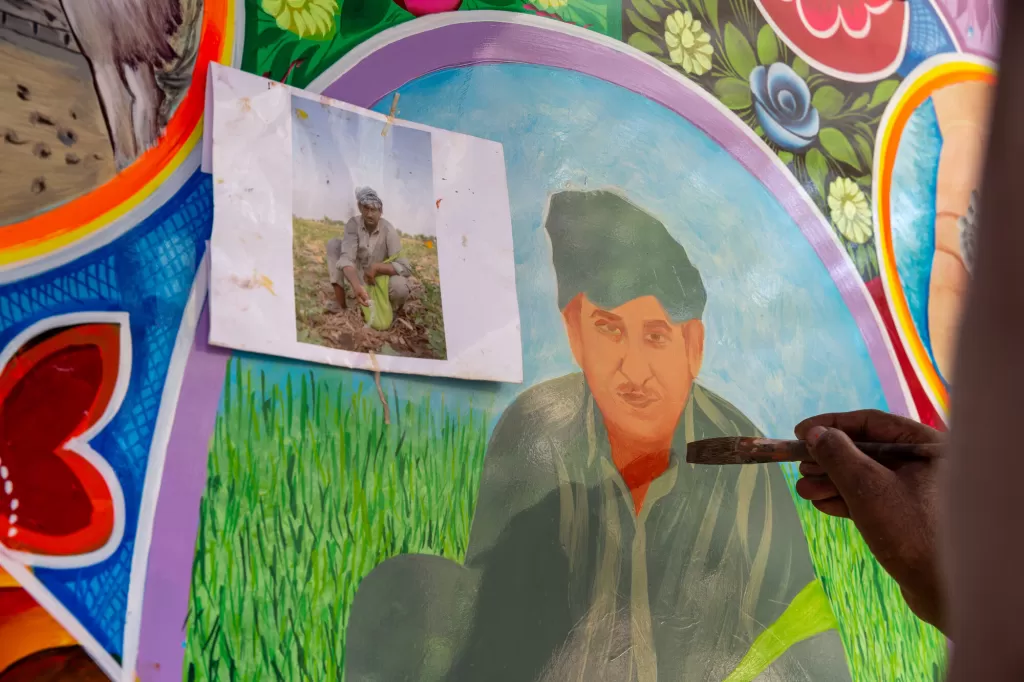 Maula Dinno being painted planting crops in the farm