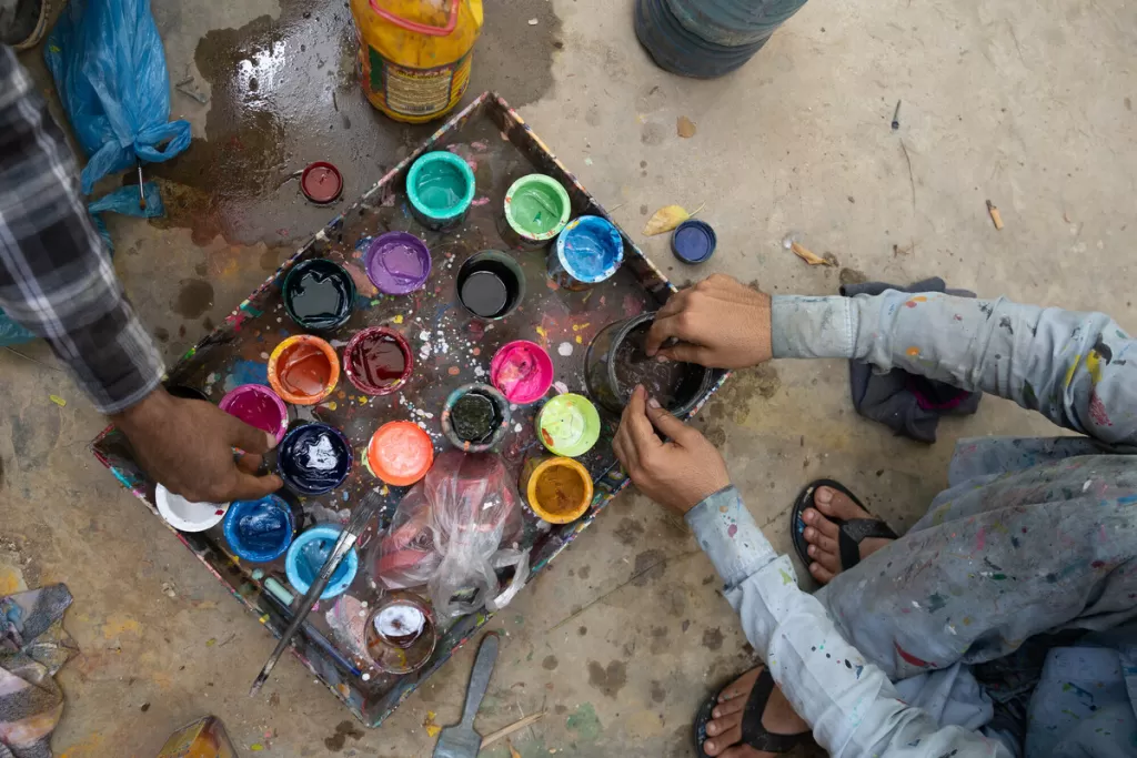Paints and brushes being cleaned up and stored after the completion of the project The truck features the stories of real people that were helped by DEC charities, in traditional Pakistani truck art style.