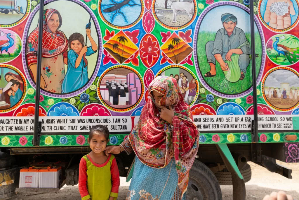 Ayra and her mother Sultana with the aid truck that has her story painted on