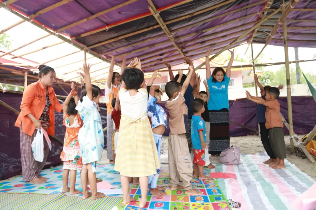 Children raise hands in session in Myanmar