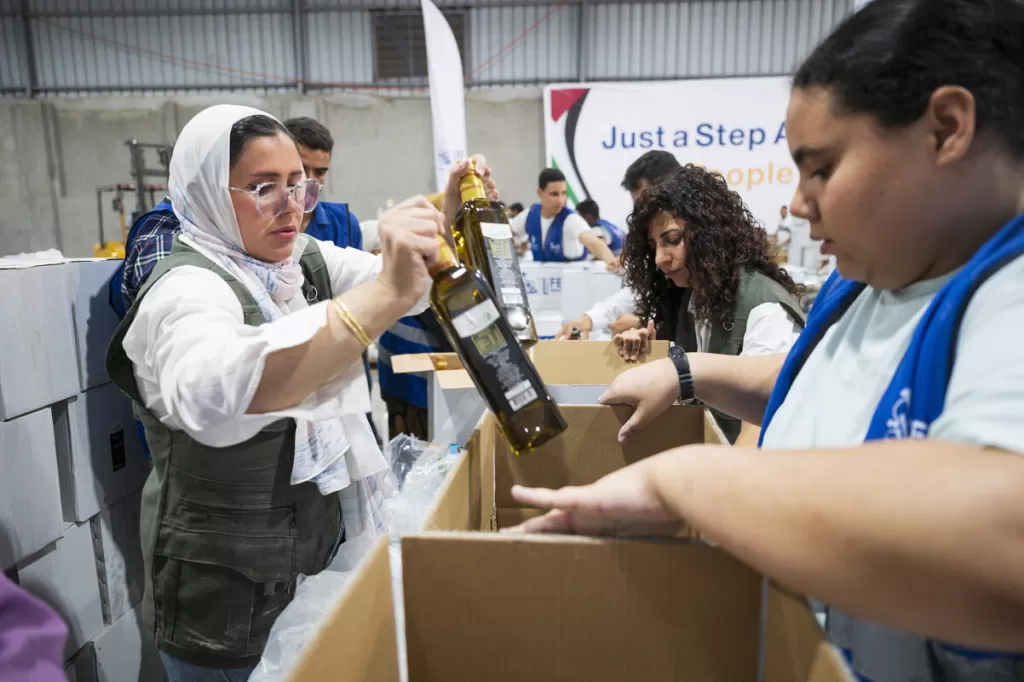 Aid wokers pack aid into boxes, ready to be trucked into Gaza. October 2025