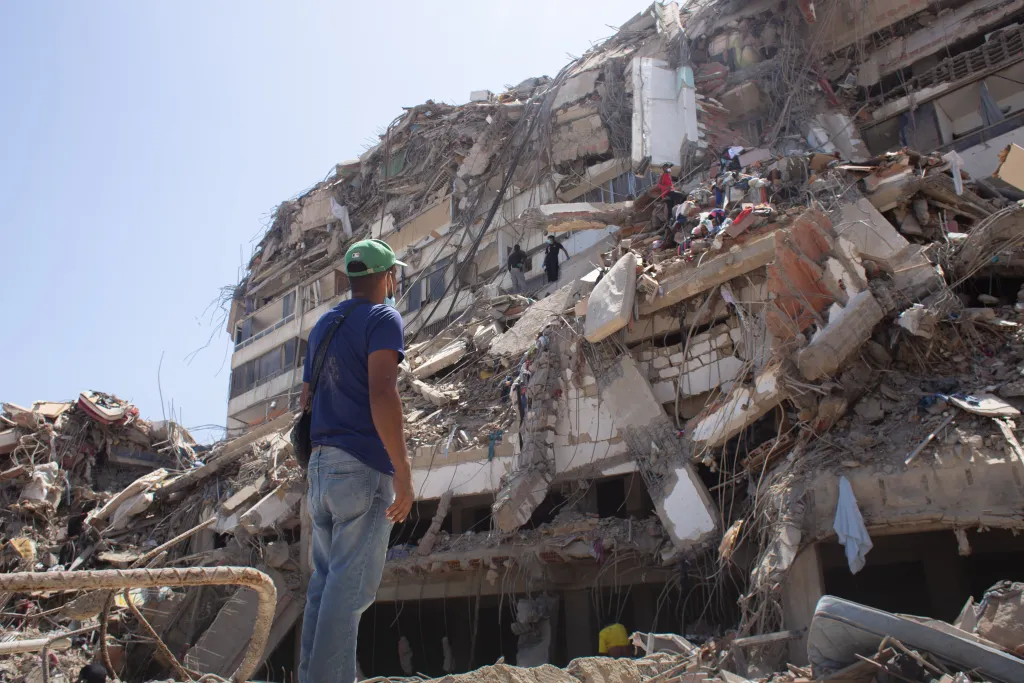 Man stands by rubble in Venezeuela 
