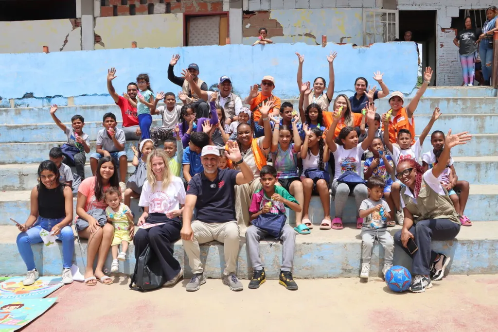 Saleh Saeed sits with a group of children outdoors at a child friendly spcae in Venezula 