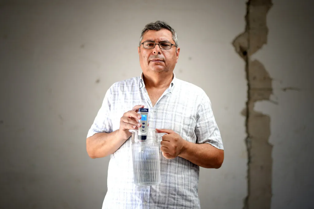 Anwar holds up bottle of water