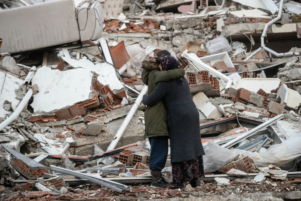 Women hug near a collapsed building in Turkey after one loses her brother in the devastating earthquake in February 2023. Photo: Burak Kara/Getty Images