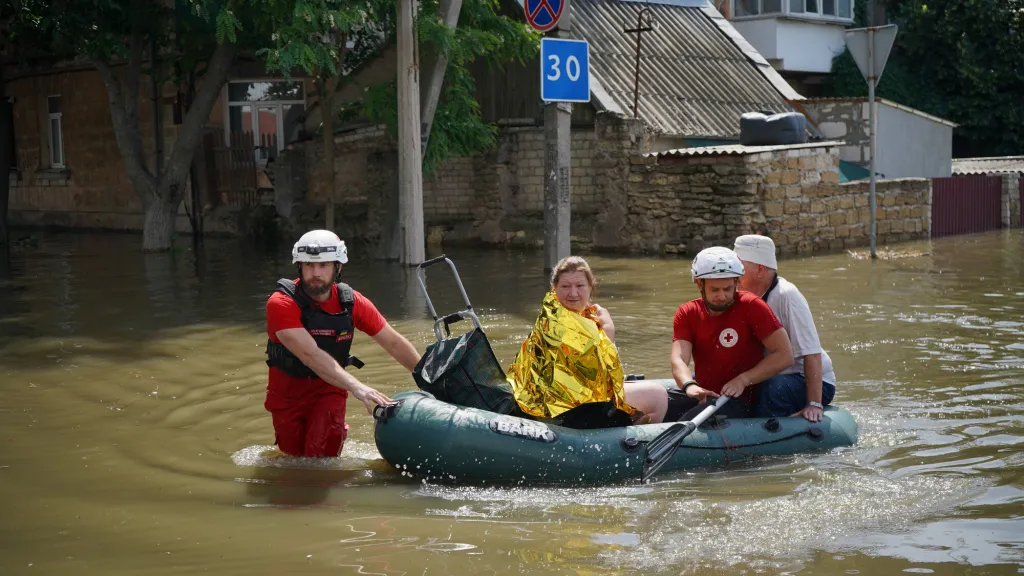 Rescue workers paddle through the waters after the dam burst.