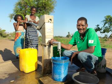 Temubura, 50, fetches water with his family from a borehole in Metuchira, Buzi. The borehole was repaired by World Vision using DEC funds after being damaged during Cyclone Idai.
