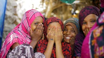 Yemeni children laugh as they peer through their fingers