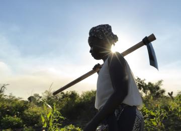 A woman carries a hoe she received from a DEC member