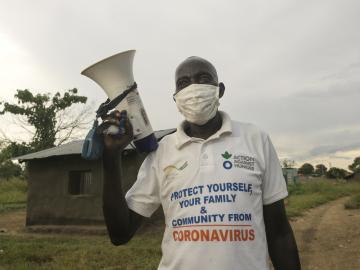 An aid worker carries a megaphone