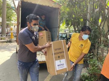 Oxfam staff unload an oxygen concentrator