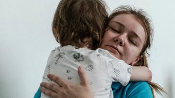 A kindergarten teacher hugs one of the boys during group playing time at the START centre for children with autism in Lviv, Ukraine